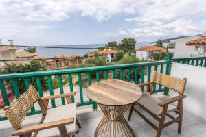 a table and chairs on a balcony with a view of the water at D&G Apartments in Agia Paraskevi
