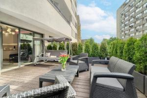 a patio with chairs and a table with flowers on it at Apartments Ostsee Suntowers TARAS in Świnoujście