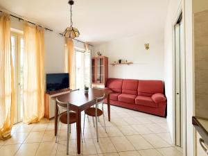sala de estar con sofá rojo y mesa en Gardappartamenti Costa Pool en Desenzano del Garda