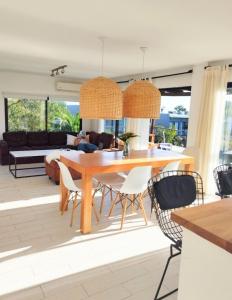 Punta Colorada的住宿－La Bonita Suites Punta Colorada，一间带木桌和椅子的用餐室