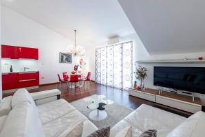 a living room with a white couch and a tv at Magic Sunset Suite in Dubrovnik