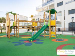 un parque infantil con un tobogán frente a un edificio en Homity Exclusive Playa Granada Beach & Golf - Aguacate Beach, en Motril