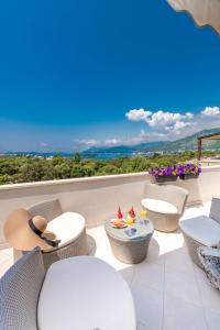 a balcony with chairs and tables and a view at Magic Sunset Suite in Dubrovnik