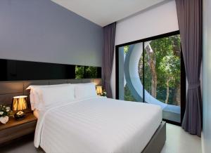 a bedroom with a large bed and a large window at Utopia Villa Naiharn Beach in Nai Harn Beach