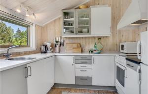 a kitchen with white cabinets and a window at 2 Bedroom Cozy Home In Jerup in Jerup