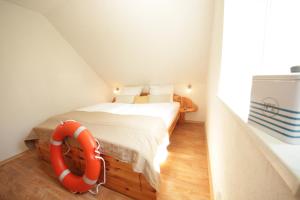 a small bedroom with a bed and a life preserver at Kojenhaus in Krummin