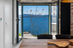 a dining room with a view of the water at Murvica resport in Murvica