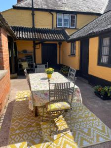 a table and chairs on the patio of a house at Ashclyst Farm Rural Retreat in Exeter