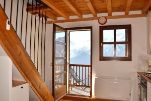 a kitchen with a staircase and a window with a view at Appartement moderne vue imprenable in Villard-Reculas
