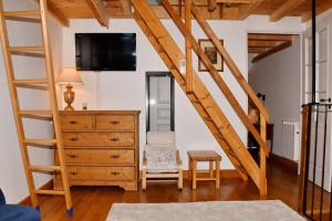 a room with a staircase and a dresser with a tv at Appartement moderne vue imprenable in Villard-Reculas