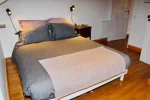 a large bed in a bedroom with two lamps on a floor at Appartement moderne vue imprenable in Villard-Reculas