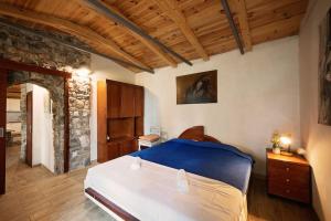 sypialnia z dużym łóżkiem i kamienną ścianą w obiekcie Holiday home Raos - a special stonehouse, Brela w Breli
