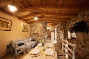 comedor con mesa, sillas y TV en Holiday home Raos - a special stonehouse, Brela, en Brela
