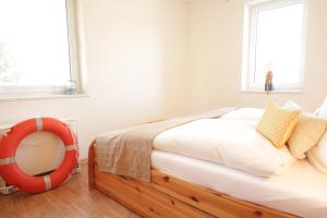 Schlafzimmer mit einem Bett mit einem Spiegel und einem Fenster in der Unterkunft Kojenhaus in Krummin