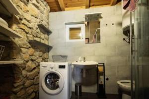 ein Badezimmer mit einer Waschmaschine und einem Waschbecken in der Unterkunft Holiday home Raos - a special stonehouse, Brela in Brela