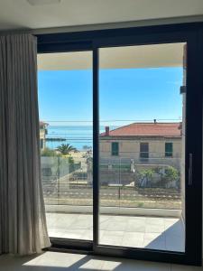 an open glass door with a view of the ocean at Mimì a Mare in Grottammare