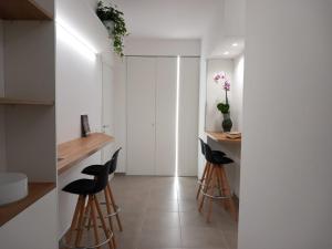 - une cuisine avec des murs blancs et des tabourets noirs dans l'établissement Blu in Blu Comfort rooms, à Terrasini