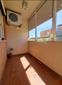 a room with a room with a fan and windows at Increíble Apartamento Familiar in Mairena del Aljarafe