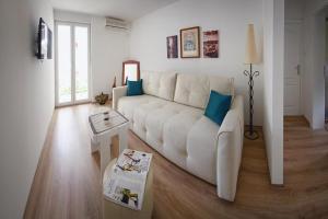 a living room with a white couch and a table at Solimar in Budva