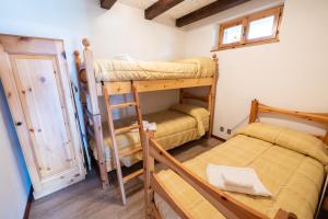 a room with two bunk beds and a table at Grazioso trilocale nel cuore di Folgaria in Folgaria