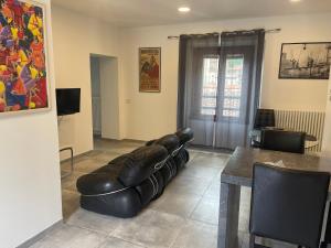 a living room with a leather couch and a table at La casa del lago di lecco in Lecco