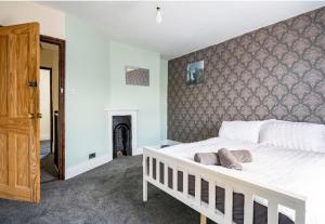 1 dormitorio con cama blanca y chimenea en Maidstone castle 3bedroom free sports free parking, en Maidstone