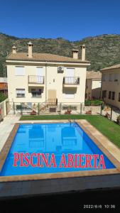 a villa with a swimming pool in front of a house at Alojamiento valeria in Arroyo Frio