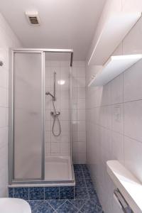 a shower stall in a bathroom with white tiles at Landhaus MONTANA in Rauris