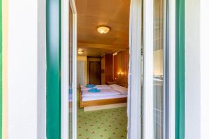 - une vue sur une chambre avec un lit par une porte dans l'établissement Landhaus MONTANA, à Rauris