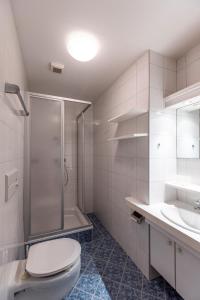 a bathroom with a shower and a toilet and a sink at Landhaus MONTANA in Rauris