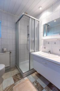 La salle de bains est pourvue d'une douche, d'un lavabo et de toilettes. dans l'établissement Landhaus MONTANA, à Rauris