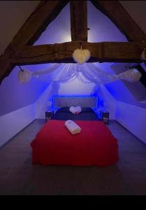 ein Schlafzimmer mit einem roten Bett mit blauer Beleuchtung in der Unterkunft la caliente in Saint-Mars-sur-la-Futaie