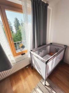 a baby crib in a room with a window at Apartma Pohorske terase Brumen Mariborsko Pohorje in Hočko Pohorje