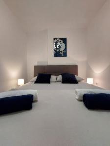 een slaapkamer met een groot wit bed met 2 kussens bij Apartman Annely in Pirovac