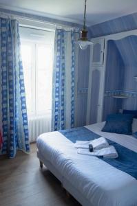 a bedroom with a large bed with blue curtains at Villa les Dunes in Saint-Jean-le-Thomas