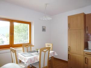 comedor con mesa, sillas y ventana en Apartment Jalps 1 in beautiful Bohinjska Bistrica, en Bohinj