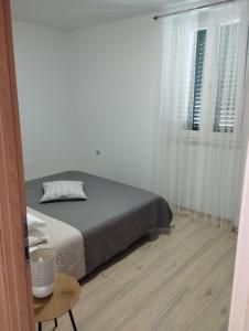 Habitación blanca con cama y ventana en Apartments Mijo, en Kaštela