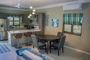 a kitchen and living room with a table and chairs at Water Mills- Beach Apartments in Mammee Bay