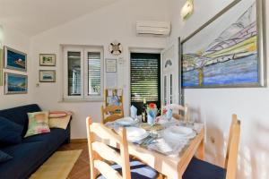 a living room with a table and a blue couch at Apartment By the sea in Donje Selo na Šolti