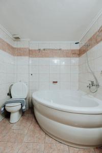 a bathroom with a white tub and a toilet at Happy Home in Kavála