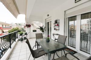 a balcony with a table and chairs on it at Happy Home in Kavála