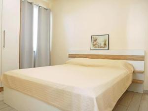 ein weißes Schlafzimmer mit einem Bett in einem Zimmer in der Unterkunft Apartmani Barbara in Ljubač