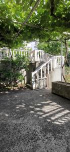 a bridge in a park with trees and a building at Sobe i apartmani Marović in Petrovac na Moru