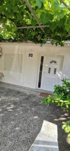 a white house with a white door and a window at Sobe i apartmani Marović in Petrovac na Moru