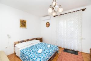 sypialnia z łóżkiem i żyrandolem w obiekcie Apartments Zivana w mieście Žaborić