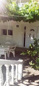a white table and chairs in front of a house at Sobe i apartmani Marović in Petrovac na Moru