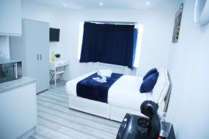 una camera con un letto e una coperta blu di Lovely Apartment with free parking on premises. a Londra