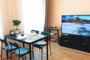 a living room with a table and a flat screen tv at Centrally located Studio apartment in Rīga