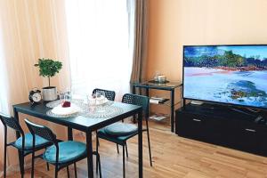 a living room with a table and a flat screen tv at Centrally located Studio apartment in Riga