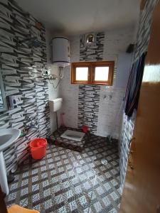 a bathroom with a toilet and a stone wall at Zikra HomeStay in Srinagar